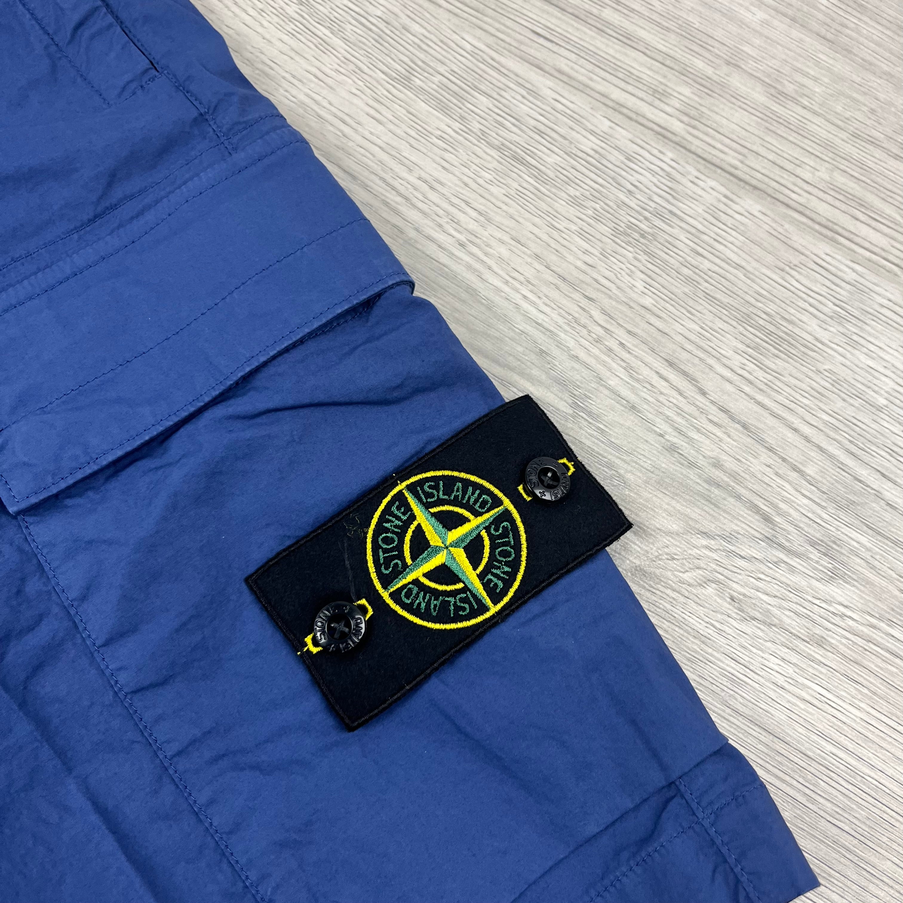Stone Island badge on a pair of Bermuda Cargo Shorts in Bright Blue. On sale at Open Attire.