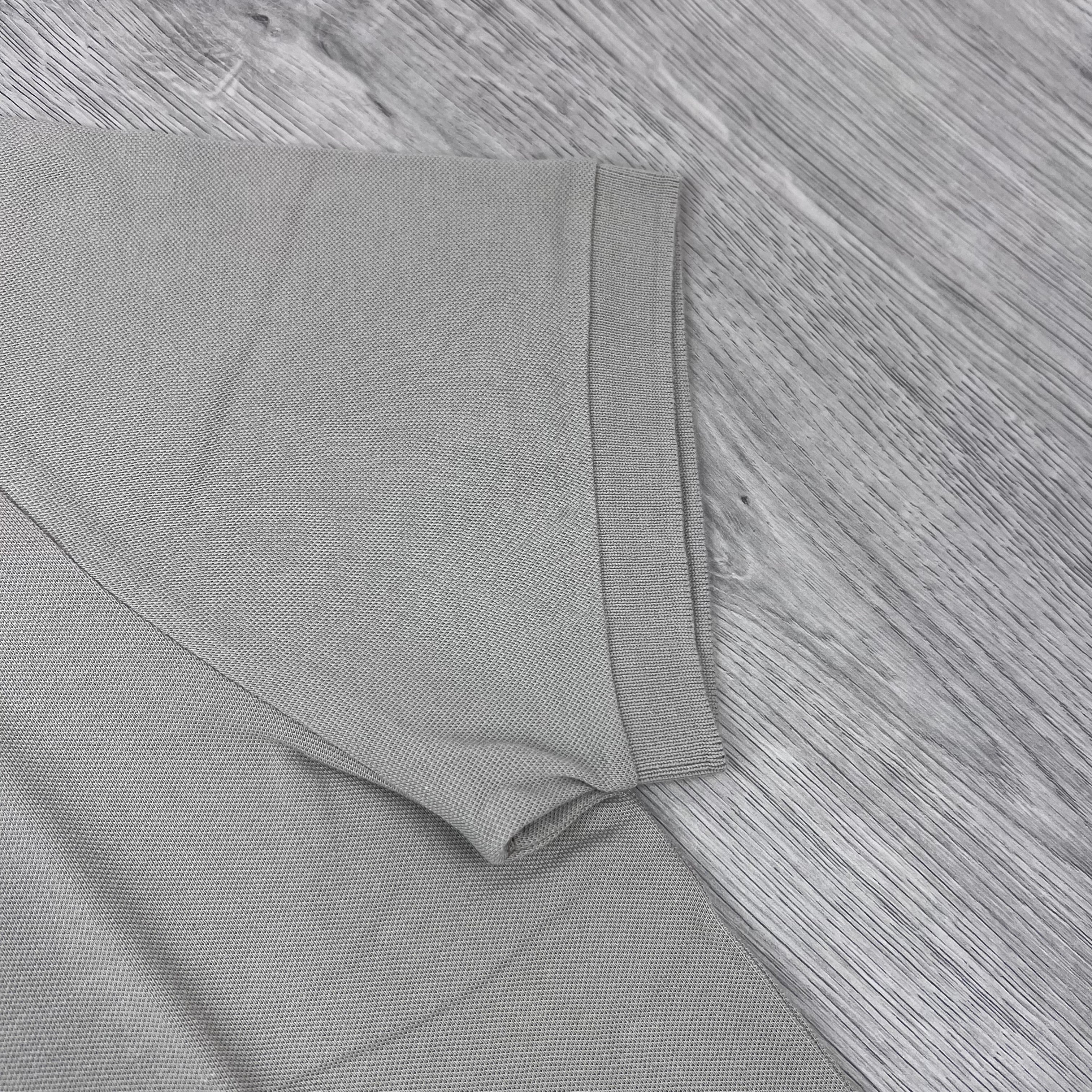 A close up front view of the cuff on a Stone Island Patch Polo Shirt in Sand.