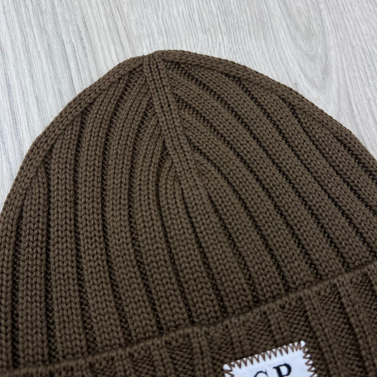 Close up view of the rib knit structure on a CP Company Merino Wool Patch Beanie in Ermine.